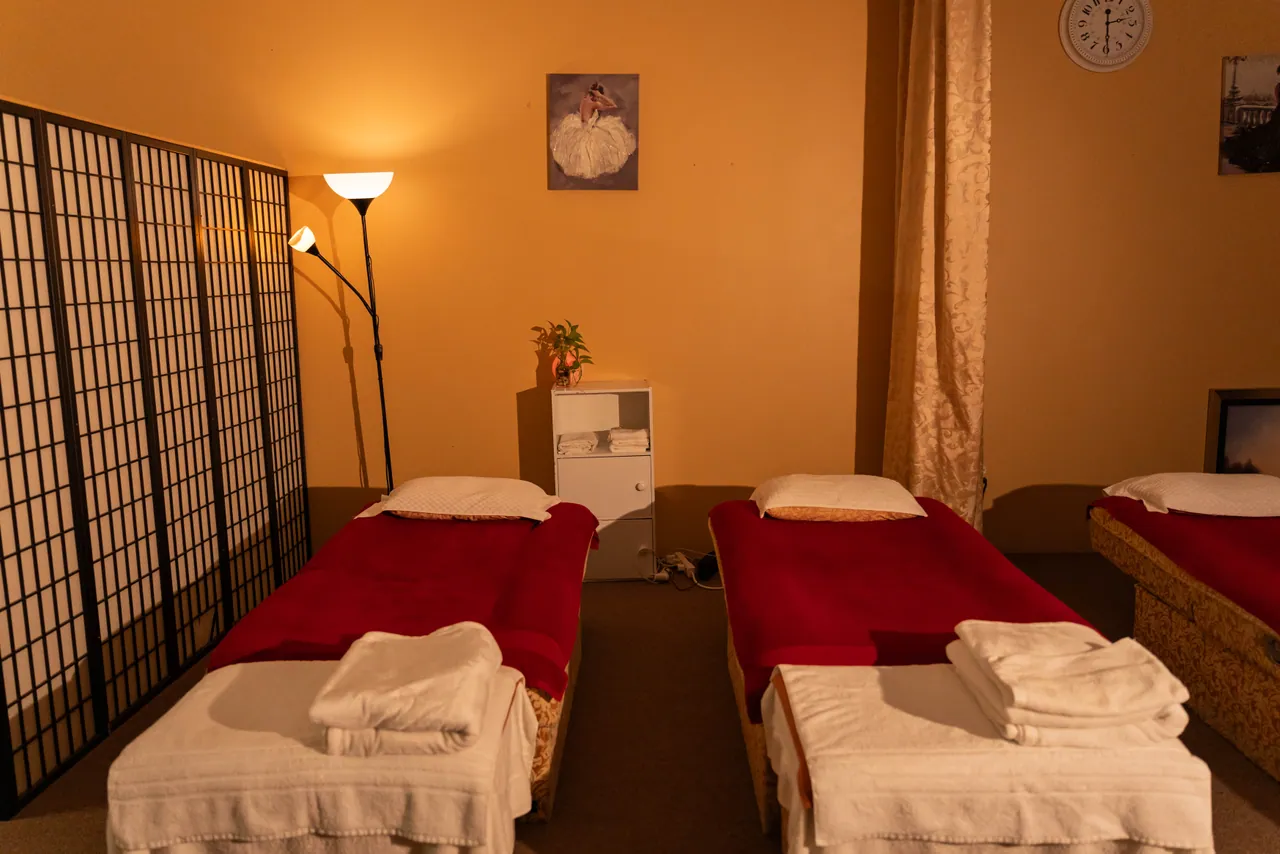 Massage beds prepared with fresh linens and screen dividers